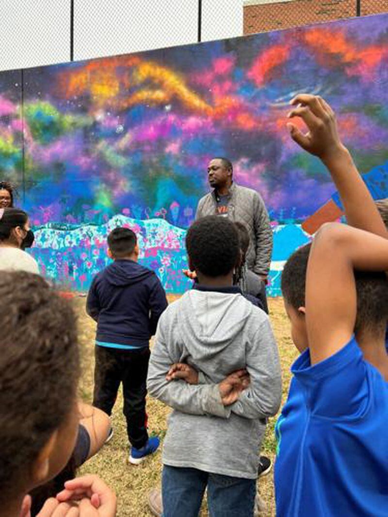 Muhammad Yungui, who created the new mural at Brumby Elementary School, speaks to students. (Courtesy of the Cobb County School District)