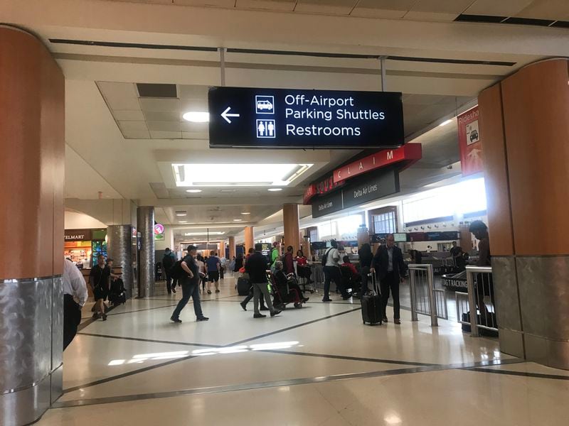 This dynamic digital sign cycles between displaying directions for Off-Airport Parking Shuttles and Restrooms, Rideshare and Delta Check-In.