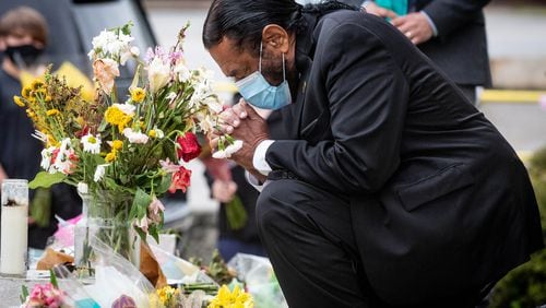 U.S. Rep. Al Green, D-Texas, of the Congressional Asian Pacific American Caucus, takes a moment to pray after laying flowers at Gold Spa in Atlanta.