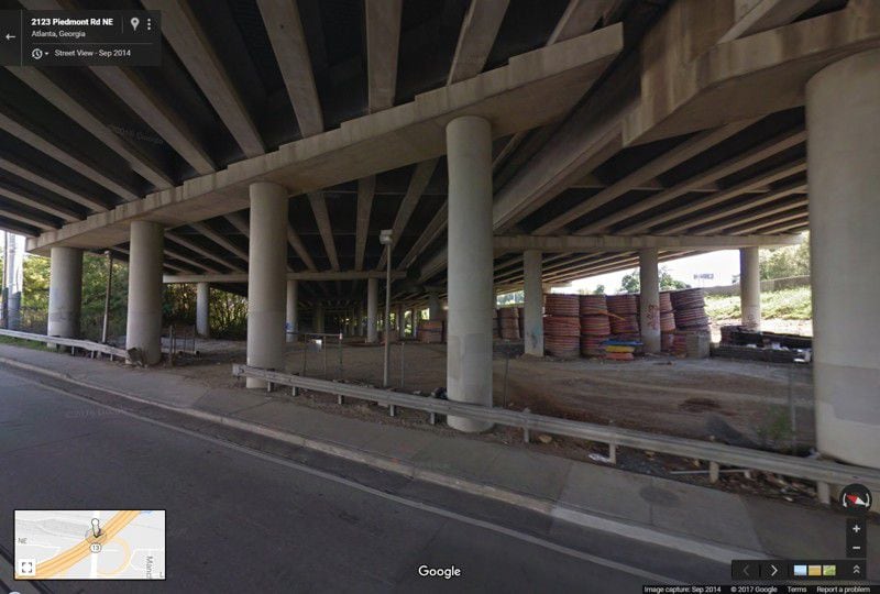 This image from Google Maps Street View shows the spools of high-density polyethylene conduit in September 2014, stored under the portion of I-85 that collapsed. The conduit burned hot enough to collapse the bridge.