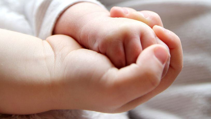 Baby and brother holding hands (stock photo)