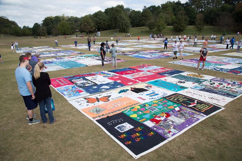 People walk around the Aids Memorial Quilt before the start of the 27th Annual AIDS, and 5K Run Sunday at Piedmont Park in Atlanta GA October 22, 2017. STEVE SCHAEFER / SPECIAL TO THE AJC