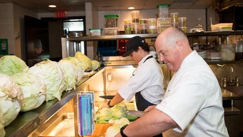 Chef Linton Hopkins and son Linton Hopkins Jr. chop cabbage for sauerkraut at Restaurant Eugene. CONTRIBUTED BY MIA YAKEL