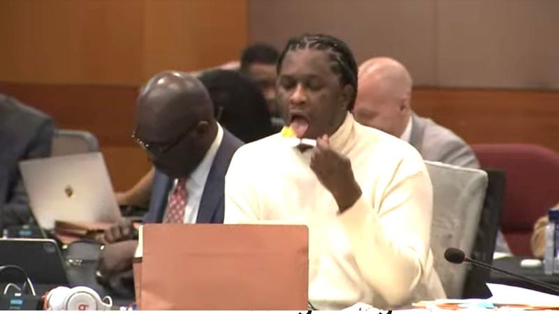 Jeffery Williams, AKA the rapper Young Thug, sneaks a bite during testimony Wednesday in the long-running RICO trial.