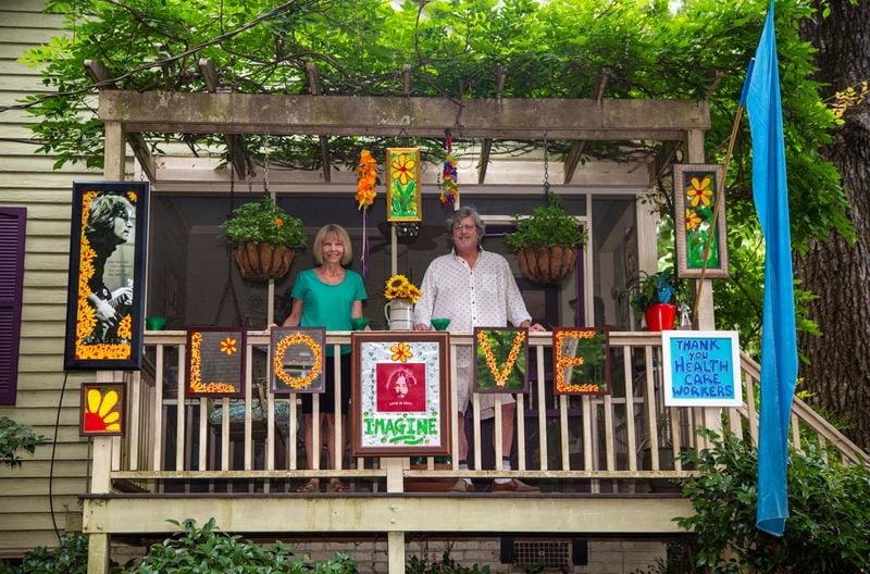 Drew and Valerie Matthews stand on the porch of their Ormewood home with their John Lennon "Love" art display they put up to cheer up their neighbors. They started their first of six different art displays during the first week of the pandemic quarantine in early April. They are donating their first display, featuring the "Mona Lisa," to the Atlanta History Center for a project on the pandemic. (Phil Skinner for The Atlanta Journal-Constitution)