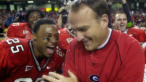 Georgia head coach Mark Richt celebrates with Michael Johnson (25) after he was doused with water as the Bulldogs beat Arkansas 30-3 in the SEC Championship at the Georgia Dome in Atlanta Saturday, Dec. 7, 2002. (AP Photo/John Bazemore)