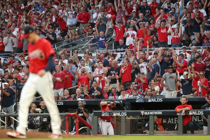 Braves fans react after relief pitcher Max Fried (left) strikes out a St. Louis Cardinals batter in the eighth inning.  (JASON GETZ/SPECIAL TO THE AJC)