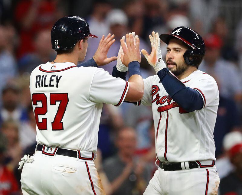 Braves catcher Travis d'Arnaud (right) gets a double high five from Austin Riley hitting a 2-run homer against the Boston Red Sox to cut the lead to 6-3 during the third inning of a MLB baseball game on Tuesday, May 10, 2022, in Atlanta.    “Curtis Compton / Curtis.Compton@ajc.com”