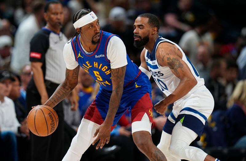 Denver Nuggets guard Kentavious Caldwell-Pope, left, looks to pass the ball as Minnesota Timberwolves guard Mike Conley, right, defends in the second half of Game 1 of an NBA basketball second-round playoff series Saturday, May 4, 2024, in Denver. (AP Photo/David Zalubowski)