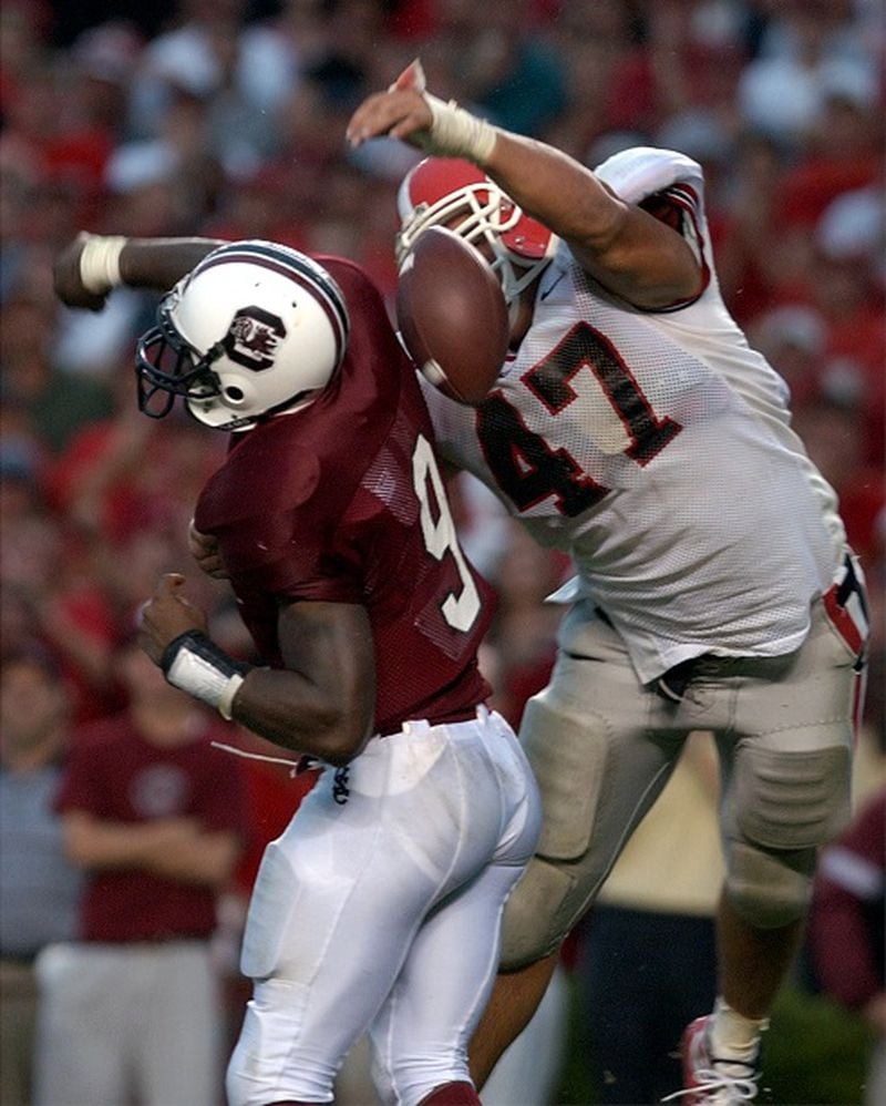 020914 - COLUMBIA, SC -- TOUCHDOWN: UGA defender David Pollack knocks the ball from USC quarterback Corey Jenkins in the endzone during the 4th quarter Saturday September 14, 2002 in Columbia, SC. Pollack recovered the ball for a touchdown to give UGA the lead. (Brant Sanderlin/AJC staff) David Pollack gets six on a rainy day. (Brant Sanderlin/AJC)