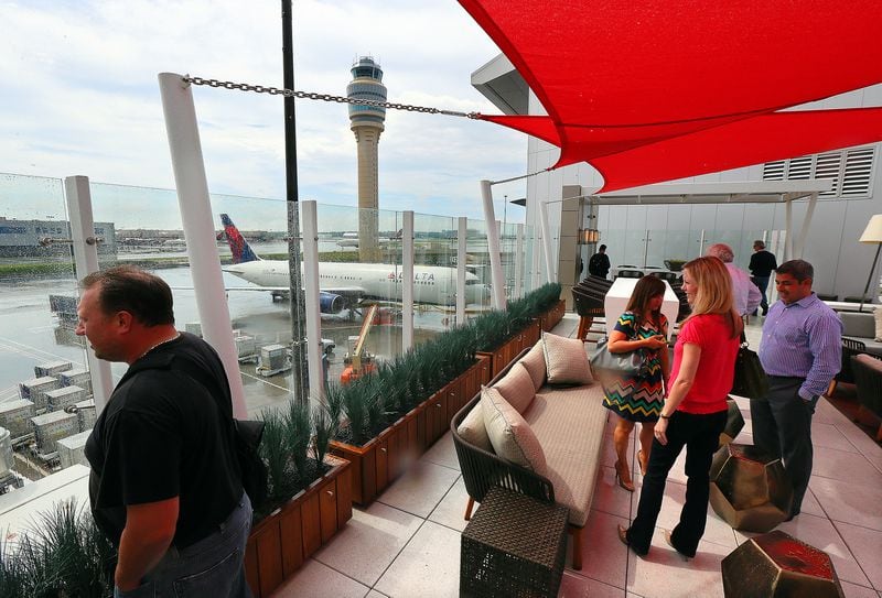 Business travelers take in the view while Delta Air Lines opens the Sky Deck at Hartsfield-Jackson International Airport on Monday, June 10, 2013, in Atlanta. The 1,710-square-foot outdoor terrace with seats and outdoor couches provides customers with unique runway views from the Delta Sky Club on Concourse F of the international terminal. It is open to Sky Club members and their guests. Others can buy club day passes that regularly cost $50, or $25 for those with certain Delta American Express cards.