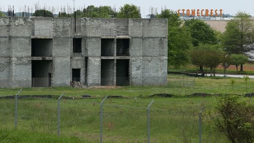 The cinderblock shell of a hotel that was supposed to be finished a decade ago sits a stone’s throw from Stonecrest Mall as a testament to the increasing vacancy of stores around the mall and the challenges facing suburban shopping centers on Wednesday, April 13, 2016. Curtis Compton / ccompton@ajc.com