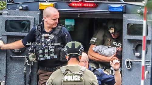 A SWAT officer cradles a baby removed from a Gwinnett County apartment during a standoff with the child's father Thursday morning.