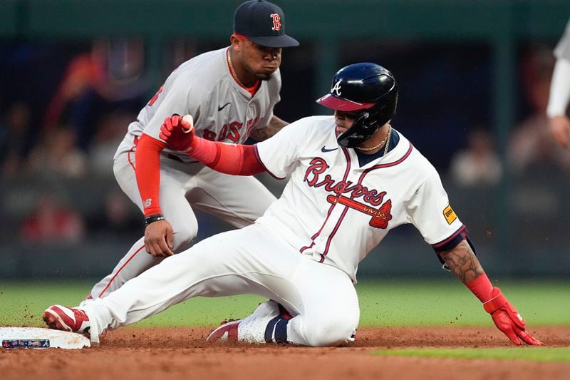 Atlanta Braves' Orlando Arcia slides into second base ahead of the throw to Boston Red Sox shortstop Ceddanne Rafaela with a double in the third inning of a baseball game Wednesday, May 8, 2024, in Atlanta. (AP Photo/John Bazemore)