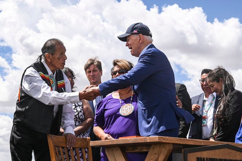 President Joe Biden greets people who joined him on stage for the signing of the establishment of the Baaj Nwaavjo I'tah Kukveni – Ancestral Footprints of the Grand Canyon National Monument, at the Historic Red Butte Airfield in Tusayan, Ariz., Aug. 8, 2023. (Kenny Holston/The New York Times)