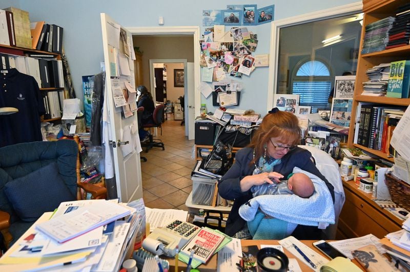 February 6, 2020 Jesup, GA - Executive office manager Antonia Harris holds 16-days old Prince Jasper Lee Holder as she works in her office at Wayne Obstetrics and Gynecology in Jesup on Thursday, February 6, 2020. An in-depth feature on how the maternal mortality crisis is playing out on the ground in rural Georgia. I'll be shadowing OBGYN Jeffrey Harris in Jesup, Ga, who sees a lot of patients on Medicaid, and interviewing members of his staff and patients. (Hyosub Shin / Hyosub.Shin@ajc.com)