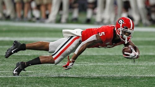 Georgia Bulldogs wide receiver Terry Godwin dives forward for a first down after a catch against the Alabama Crimson Tide in the SEC Championship game Saturday, Dec. 1, 2018, at Mercedes-Benz  Stadium in Atlanta.  BOB ANDRES / BANDRES@AJC.COM