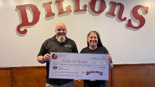 Dillons general manager Daniel Maloney and owner Donna Staton hold a replica check of more than $4,000 that was presented to Folds of Honor Georgia. (Handout)
