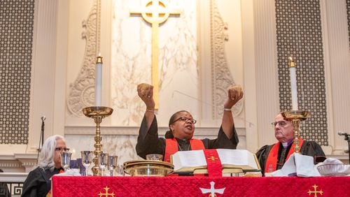 Bishop Robin Dease, right, breaks bread for communion during her installed as leader of the North Georgia Conference United Methodist Church on Sunday, Jan 8, 2023.  She is the first African-American female appointed to the position.   (Jenni Girtman for the Atlanta Journal-Constitution)