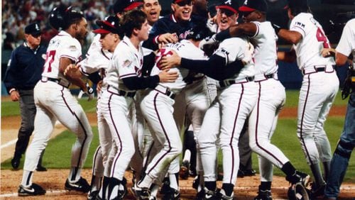 Braves players surround Mark Lemke after he scored the winning run in the ninth inning to beat Minnesota in Game 4 of the 1991 World Series, evening the series at two games each. (Frank Niemer / AJC)