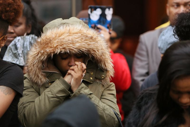 Mia Jordan, co-worker of Anitra Gunn, prays through tears after mourners released balloons in memory of Anitra Gunn at the Eighteen36 Restaurant and Lounge, where she worked, in Fort Valley on Thursday, February 20, 2020. (Photo/Leah Yetter for the AJC)