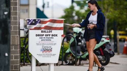 A woman drops off her mail-in ballot outside the Denver Elections Division polling center as she votes in June's Colorado primary. (Michael Ciaglo/Getty Images/TNS)