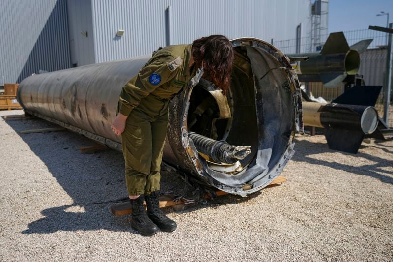 Israeli military deputy head of the IDF International press department, first lieutenant Masha Michelson, display to the media one of the Iranian ballistic missiles Israel intercepted over the weekend, in Julis army base, southern Israel, Tuesday, April 16, 2024. Israel says that Iran launched over 300 missiles and attack drones in the weekend attack. It says most of the incoming fire was intercepted, but a handful of missiles landed in Israel, causing minor damage and wounding a young girl. (AP Photo/Tsafrir Abayov)