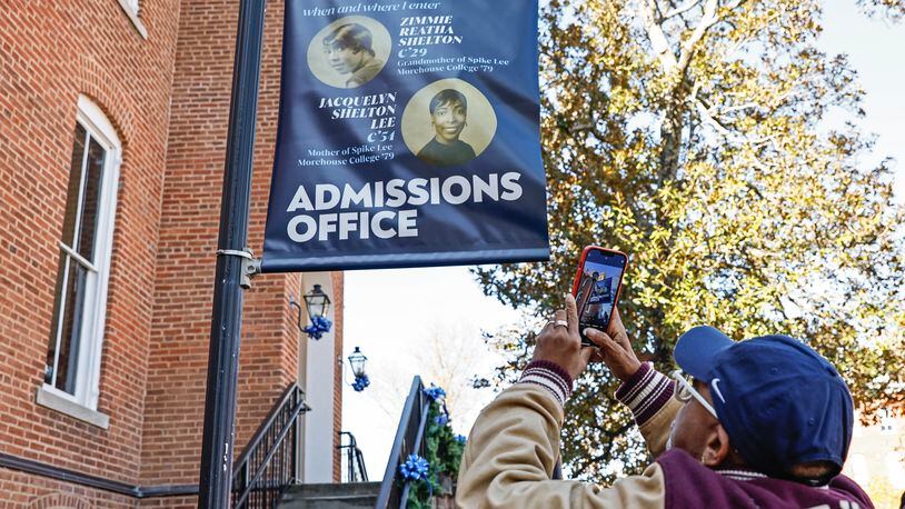 Film director Spike Lee takes a photo of signage for the admissions office dedicated to his mother and grandmother at Spelman College on Monday, November 28, 2022. (Natrice Miller/natrice.miller@ajc.com)  