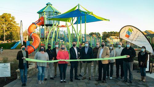 Johns Creek city officials, staff and parks advisory committee members cut the ribbon to officially open Morton Road Park.