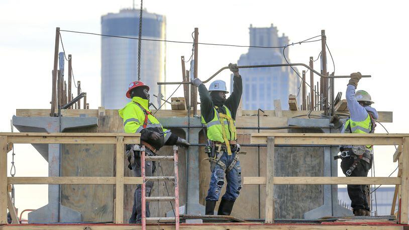 Construction workers early this year working on the Northside Drive Pedestrian Bridge that will connect Mercedes-Benz Stadium and the Vine City MARTA station. JOHN SPINK/JSPINK@AJC.COM