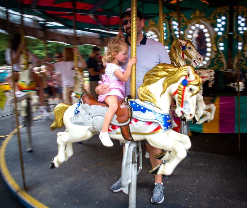 People enjoy the carousel in the amusement park rides area during the Lemonade Days Festival in Dunwoody on Sunday, August 22, 2021. STEVE SCHAEFER FOR THE ATLANTA JOURNAL-CONSTITUTION
