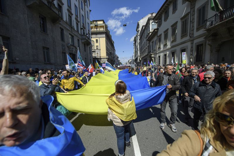 People unfold a Ukrainian flag as they march on the occasion of Liberation Day in Milan, Italy, Thursday, April 25, 2024. Italy is marking its liberation from Nazi occupation and fascist rule amid a fresh media controversy over the legacy of Italian fascist complicity in the Holocaust and World War II-era crimes. (Claudio Furlan/LaPresse via AP)