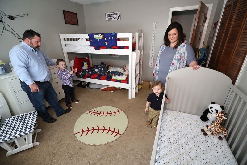 Melanie and Kris Lambert, with their sons, Connor, 5, and Harrison, 2, prepare the boys' room for the birth of their third son, Hank. (Curtis Compton / Curtis.Compton@ajc.com)