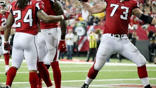 Falcons tackle Ryan Schraeder gladly does the honors, spiking the ball following a Devonta Freeman score. (Curtis Compton /ccompton@ajc.com)