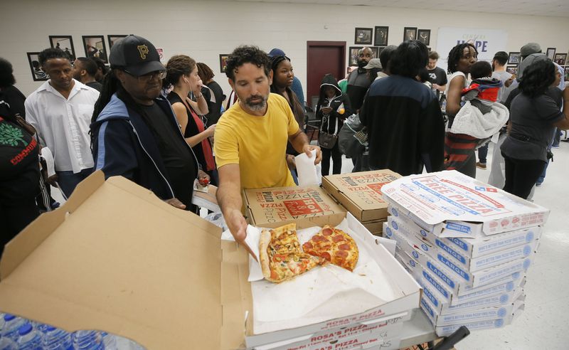 11/6/18 - Atlanta - Angel Poventud, who voted early, volunteers his time to hand out pizza and snacks to people waiting in line.  The wait time to vote at the Pittman Park precinct in Atlanta was reported to be three hours.  Pizza and snacks were donated for the people waiting in line.   BOB ANDRES / BANDRES@AJC.COM