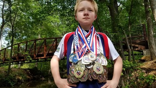 P.J. Ball, 13, shows off the nearly 80 medals he has won in sport stacking competitions around the world. The Villa Rica teen discovered the sport at age 7 while watching YouTube videos. CONTRIBUTED