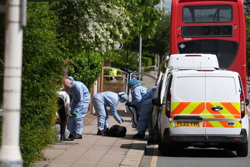 Forensic investigators in Hainault, north east London, Tuesday April 30, 2024. A man wielding a sword attacked members of the public and police officers in a east London suburb, killing a 13-year-old boy and injuring four others, authorities said Tuesday. A 36-year-old man was arrested at the scene, police said. Chief Supt. Stuart Bell said the incident is not being treated as terror-related or a “targeted attack.” (Jordan Pettitt/PA via AP)