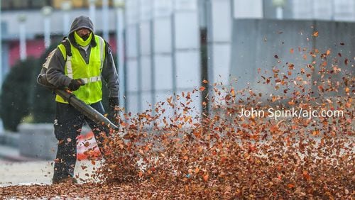 Marco Carbajal with Brightview Landscape Services pushes through low temperatures Thursday morning while blowing leaves at the Georgia World Congress Center.
