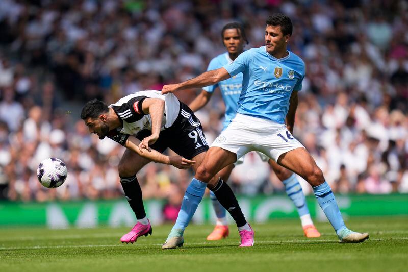 Fulham's Armando Broja, left, challenges for the ball with Manchester City's Rodrigo during the English Premier League soccer match between Fulham and Manchester City at the Craven Cottage Stadium in London, Saturday, May 11, 2024. (AP Photo/Kirsty Wigglesworth)