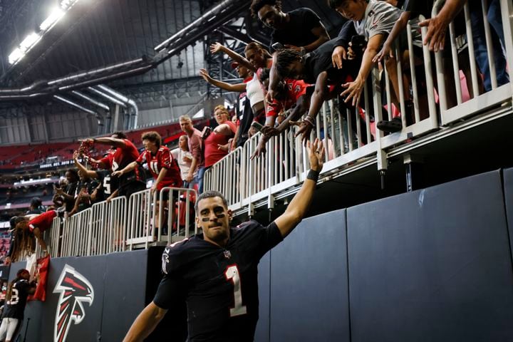 Falcons quarterback Marcus Mariota celebrates with fans after Atlanta defeated the 49ers 28-14 on Sunday at Mercedes-Benz Stadium. (Miguel Martinez / miguel.martinezjimenez@ajc.com)