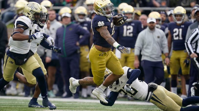 Notre Dame's Kyren Williams (23) runs past Georgia Tech's Miles Brooks (20) during the first half of an NCAA college football game, Saturday, Nov. 20, 2021, in South Bend, Ind. (AP Photo/Darron Cummings)