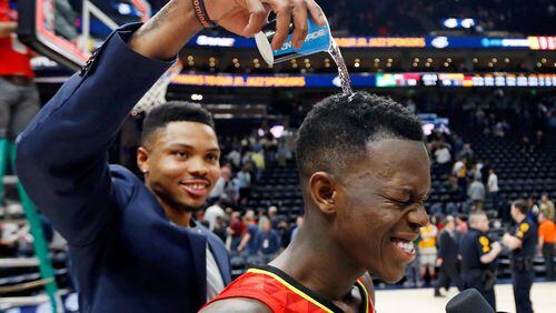 Atlanta Hawks guard Kent Bazemore, left, pours water over the head of Atlanta Hawks guard Dennis Schroder, right, while celebrating after their NBA basketball game against the Utah Jazz Tuesday, March 20, 2018, in Salt Lake City. (AP Photo/Rick Bowmer)