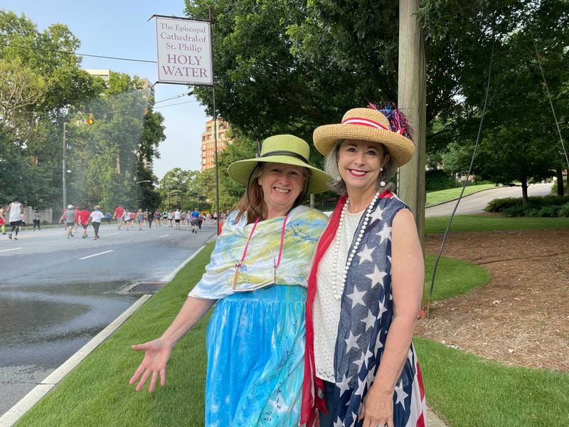 Darrin Ellis-May (right) and Saye Sutton cheer on the runners Saturday, July 3, 2021. (Photo: Anjali Huynh/AJC)
