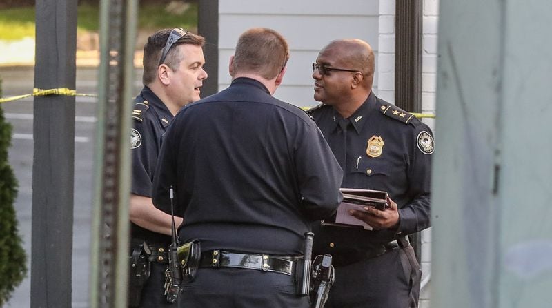 Atlanta police Deputy Chief Charles Hampton Jr. (right) speaks with officers on the scene of a deadly shooting Thursday morning at the One Riverside West community on Main Street.