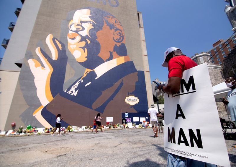  David Richardson holds a sign that reads I Am Man while visiting the John Lewis memorial under the John Lewis mural on Auburn Ave, Sunday, July 19, 2020. STEVE SCHAEFER FOR THE ATLANTA JOURNAL-CONSTITUTION
