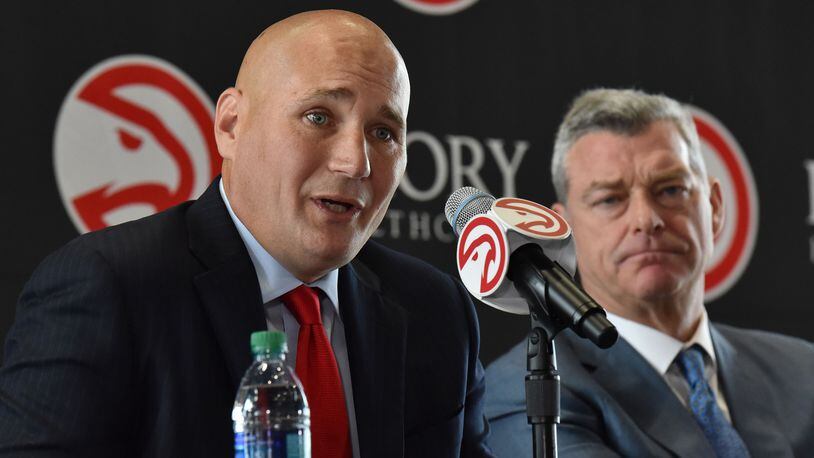 New Hawks general manager Travis Schlenk speaks as principal owner Tony Ressler looks on during the introductory news conference Friday at Philips Arena. (Hyosub Shin/hshin@ajc.com)
