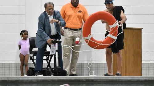 Ambassador Andrew Young (left) and his brother Walter Young toss a lifeguard ring during a ribbon cutting ceremony to inaugurate the new pool at Andrew and Walter Young Family YMCA, Wednesday, July 5, 2023, in Atlanta. (Hyosub Shin / Hyosub.Shin@ajc.com)