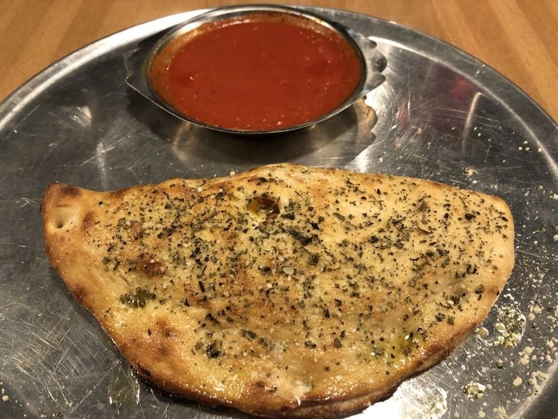 You can decide what to add to the mozzarella and ricotta in your Junior’s Pizza calzone, shown with marinara sauce. CONTRIBUTED BY WENDELL BROCK