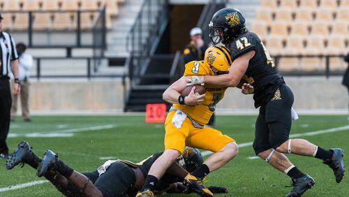 Quarterback Chandler Burks (3) is taken down by Bryson Armstrong (42) and Izzy Sam (49) during the 2017 Kennesaw State University spring football game. -- Cory Hancock photo