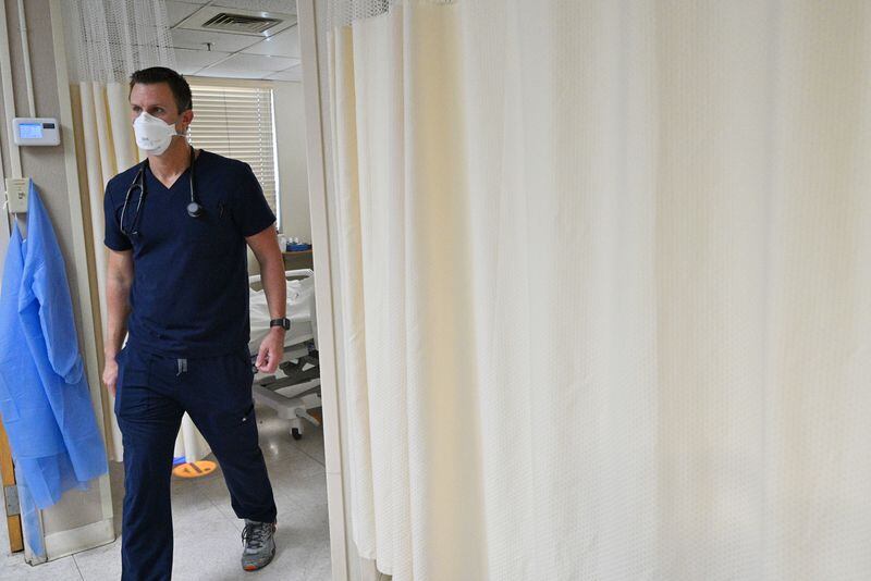 In this file photo, Dr. Jason Laney walks out of the curtain after seeing a patient in an intensive care unit (ICU) at Jeff Davis Hospital in Hazlehurst in September. (Hyosub Shin / Hyosub.Shin@ajc.com)